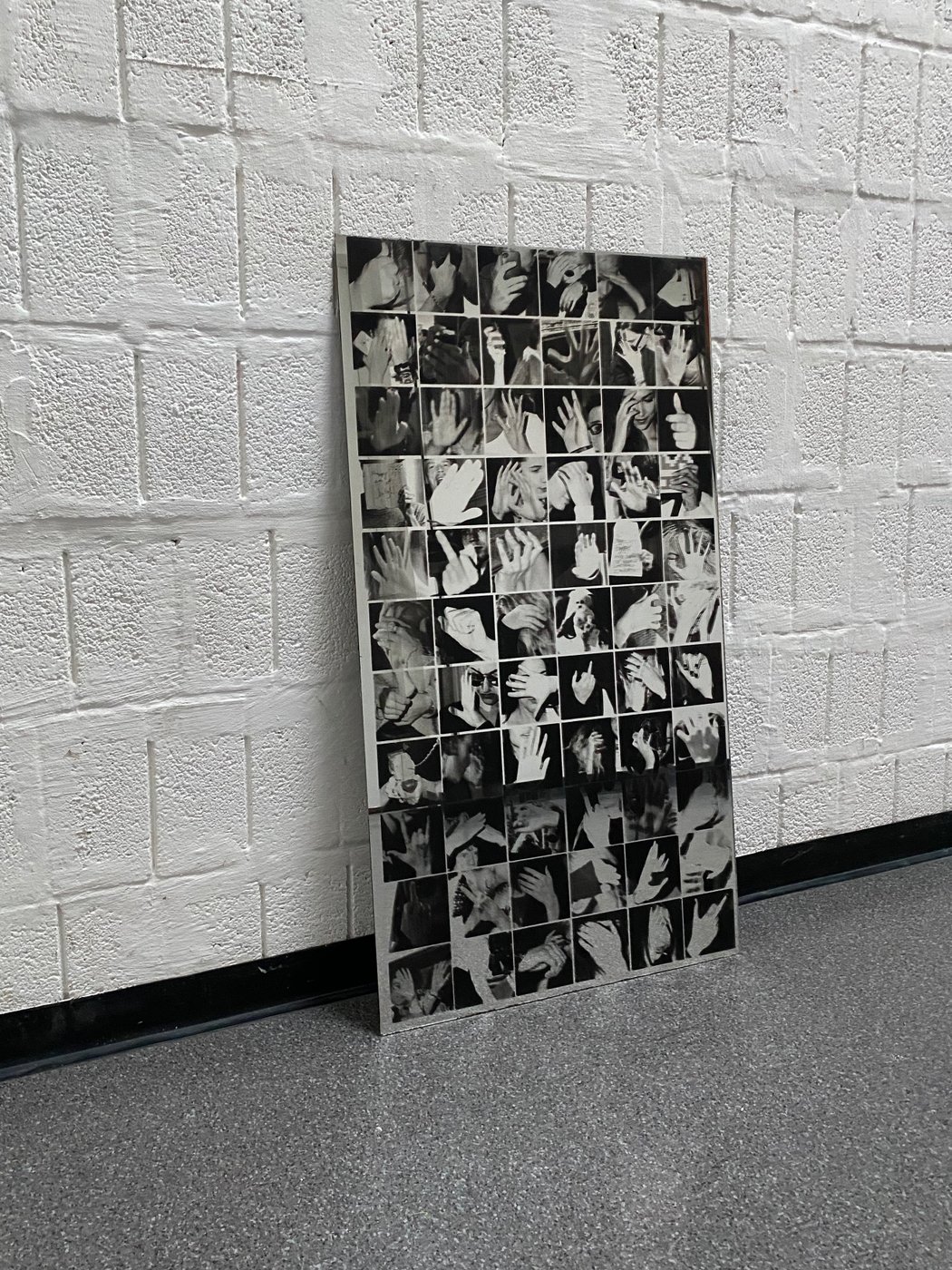 Schwarz-weiß Foto mit deiner an eine Wand gelehnte Tafel mit Abbildungen von Handgesten