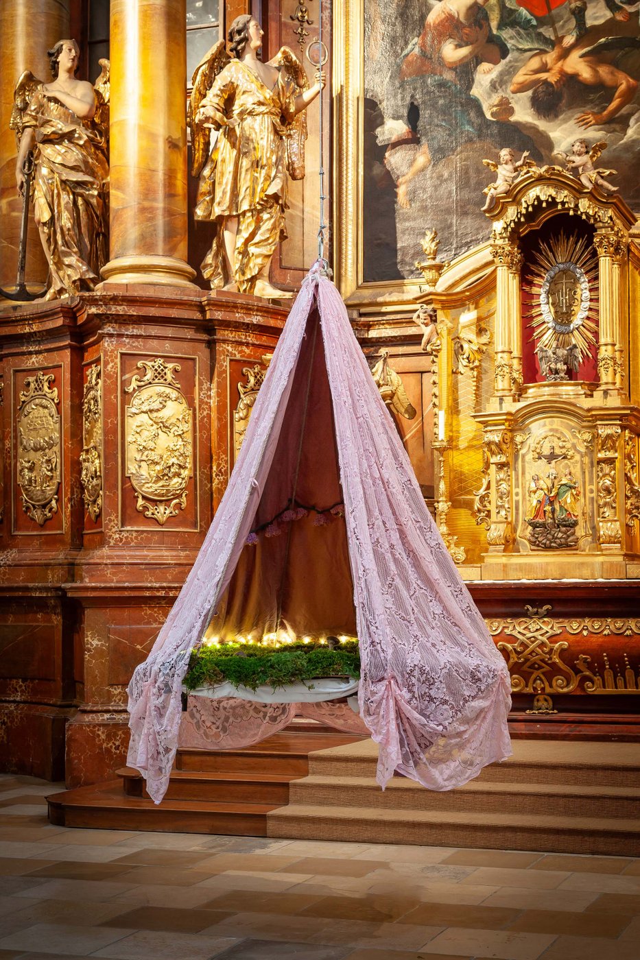 in einem goldenen Altarbereich hängt eine Wieseninstallation mit Rosa Vorhang