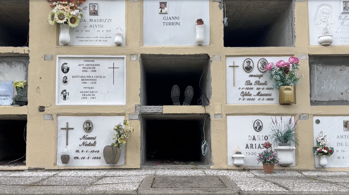 Grabstätte mit offenen Wandgräbern, in der Mitte sind Schuhe, als ob eine Person drinnen liegt