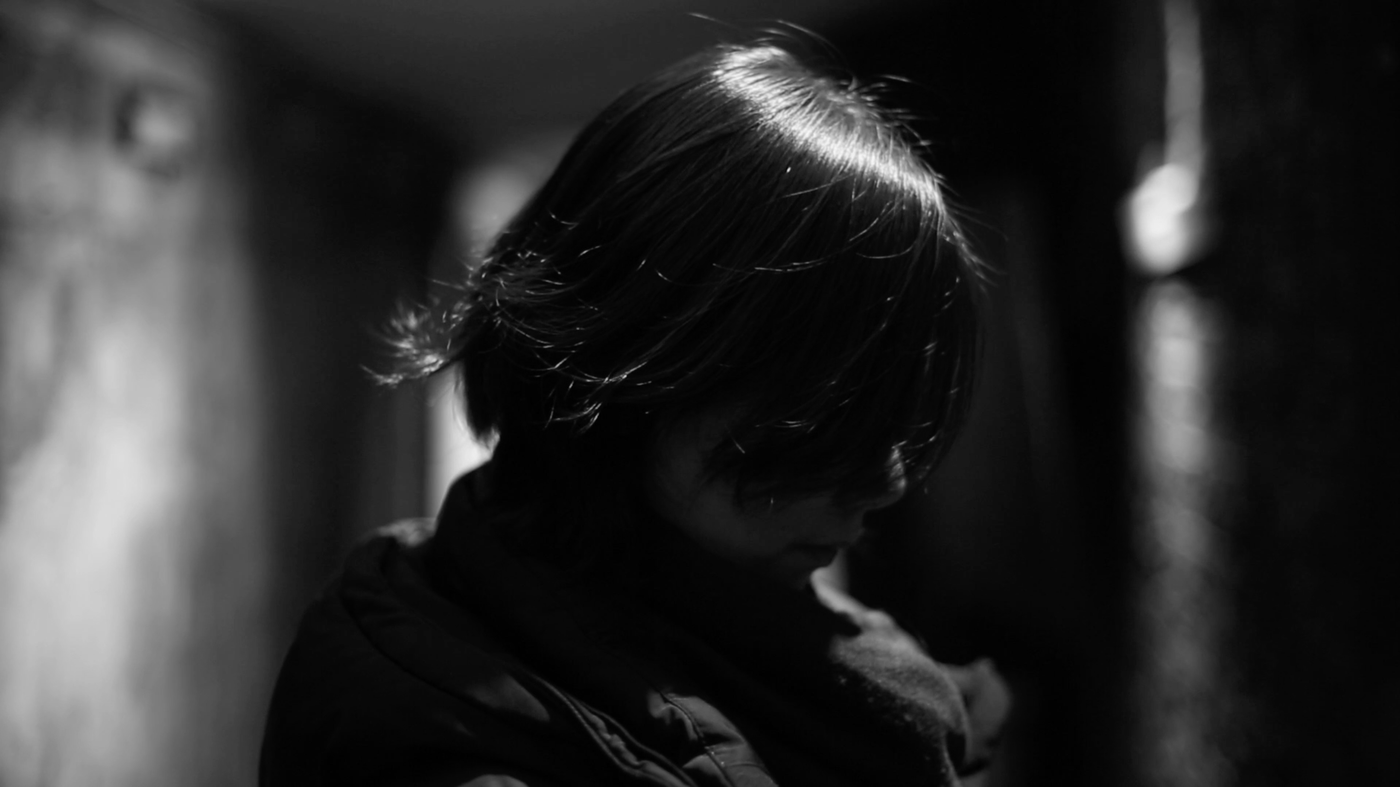 schwarz weiß Foto, Profil einer Frau mit kurzen Haaren die ihr ins Gesicht hängen