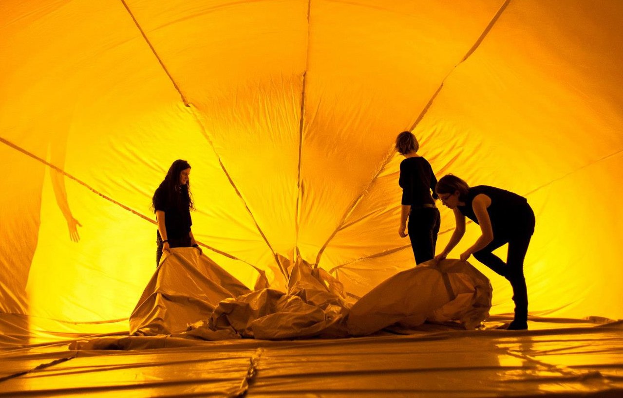 Aufblasbare gelbe Konstruktion von innen, mit drei Personen
