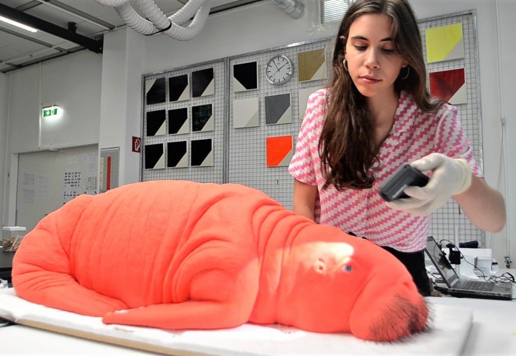 Foto2 Rotes tierähnliches Objekt und eine Studentin, die daran arbeitet