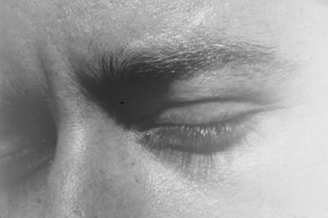 Ein schwarz-weiß Filmstill der 16mm Arbeit von Nazli Dincel, Instructions on How to Make a Film. Man sieht eine Nahaufnahme eines Gesichts mit geschlossenen Augen.