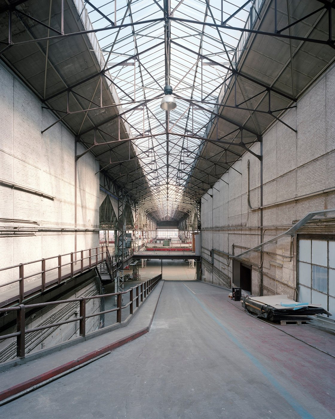 Farbfotographie eines industriellen Gebäudes, der Blick richtet sich eine Rampe hinunter.