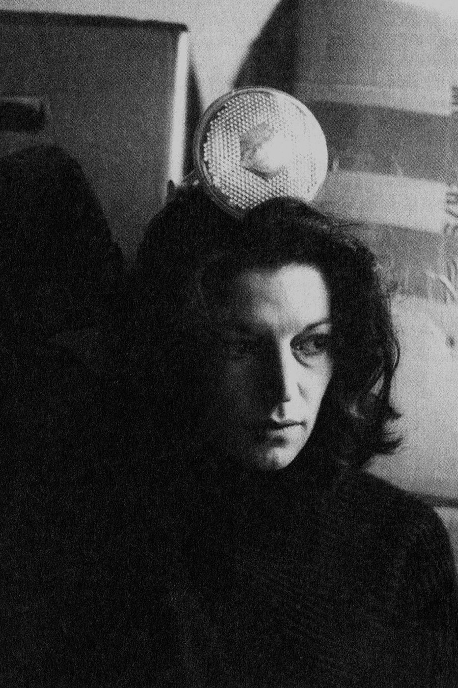 Portrait von Cathrin Pichler in Schwarz-Weiss, im Hintergrund sind eine Lampe und Kartonkisten zu erkennen.