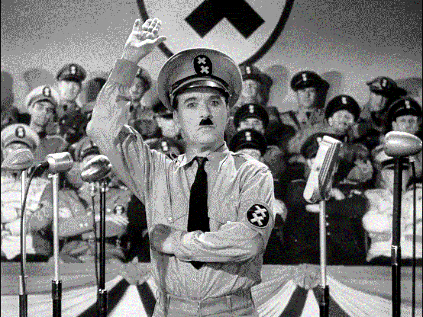 schwarz-weiß Filmstill aus dem Film der große Diktator, indem Charlie Chaplin als Hitler verkleidet ist