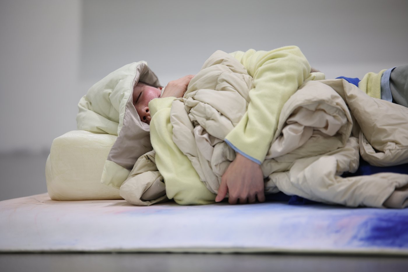 Detailaufnahme einer in Decken gehüllten, schlafenden Person.