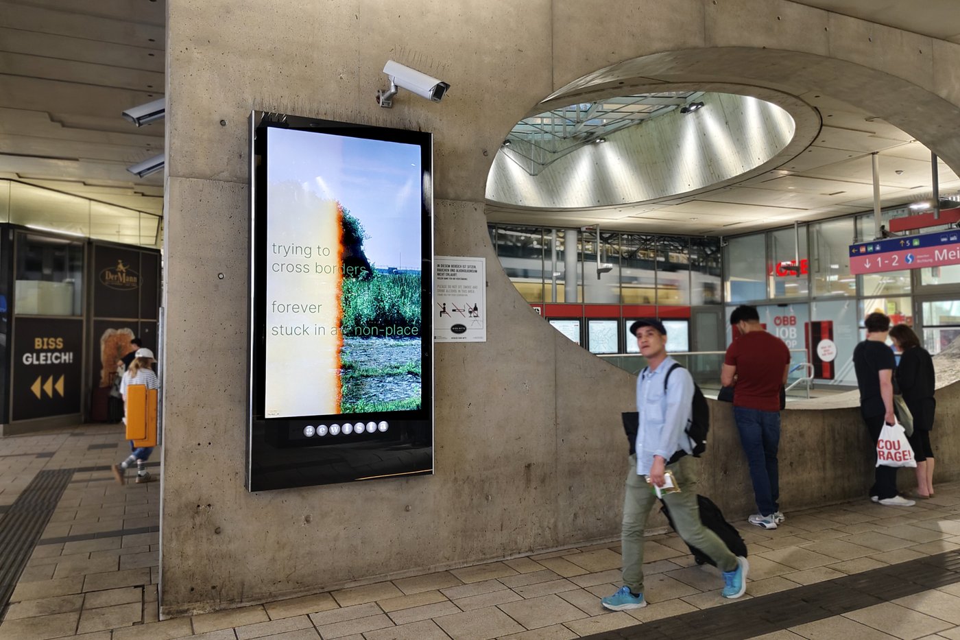 Foto eines Bahnhofsplatzes mit einer Werbeanzeige im Zentrum des Bildes