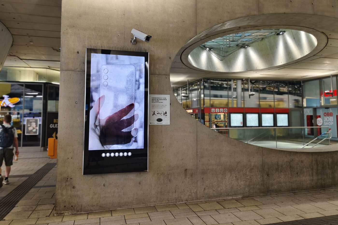 Foto eines Bahnhofplatzes mit Werbeanszeigen