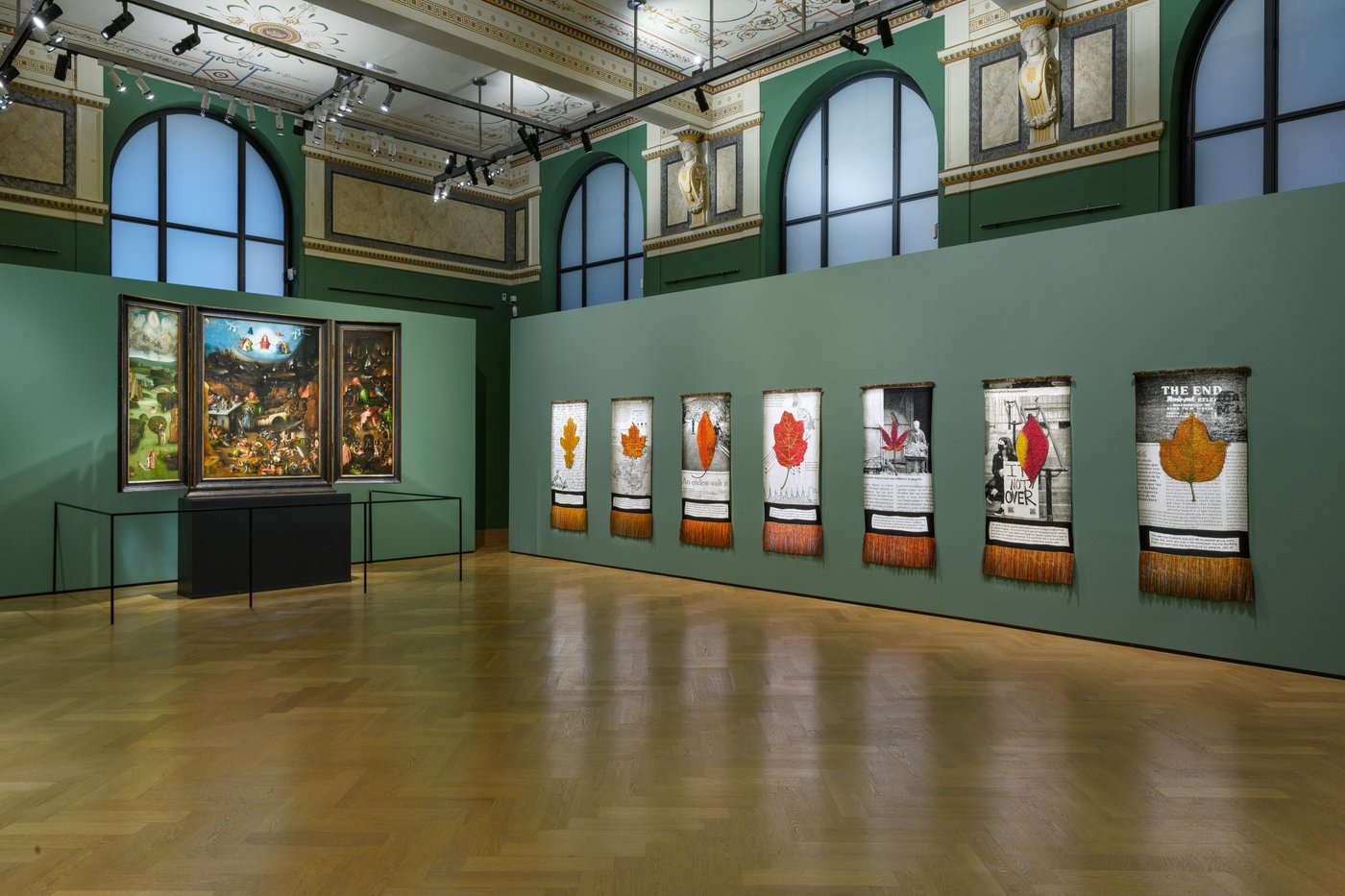 Grüne Ausstellungswand mit Kunstwerken