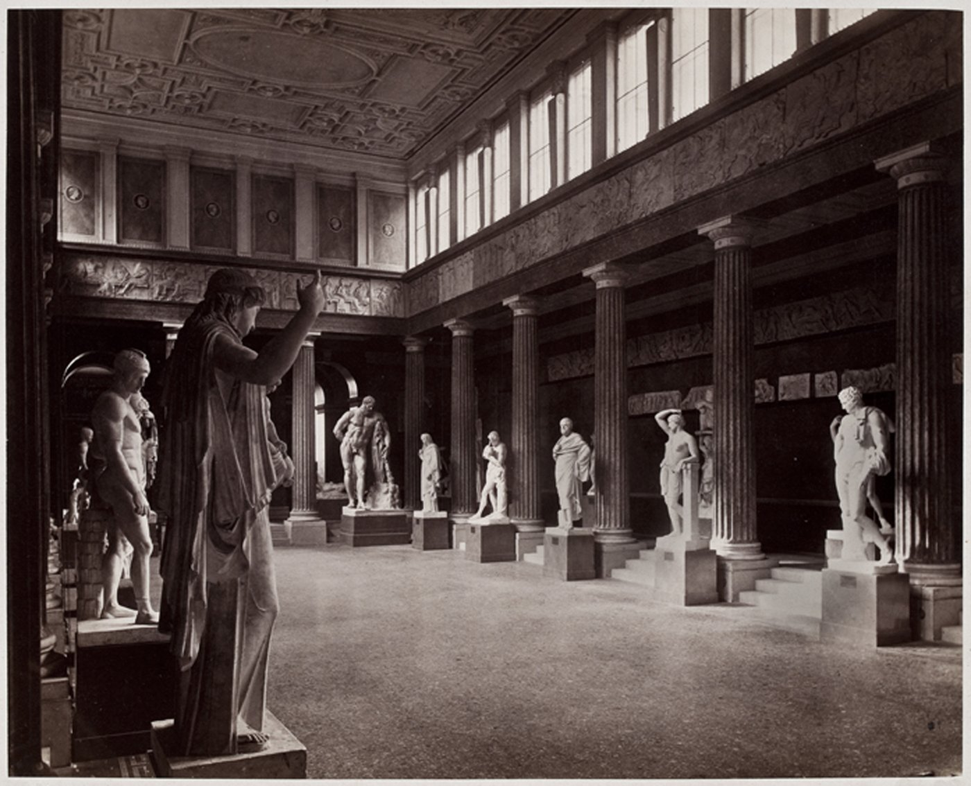 Die Fotografie zeigt einen Einblick in die Aula des Akademiegebäudes, in der Abgüsse von antiken Skulpturen aufgestellt sind.
