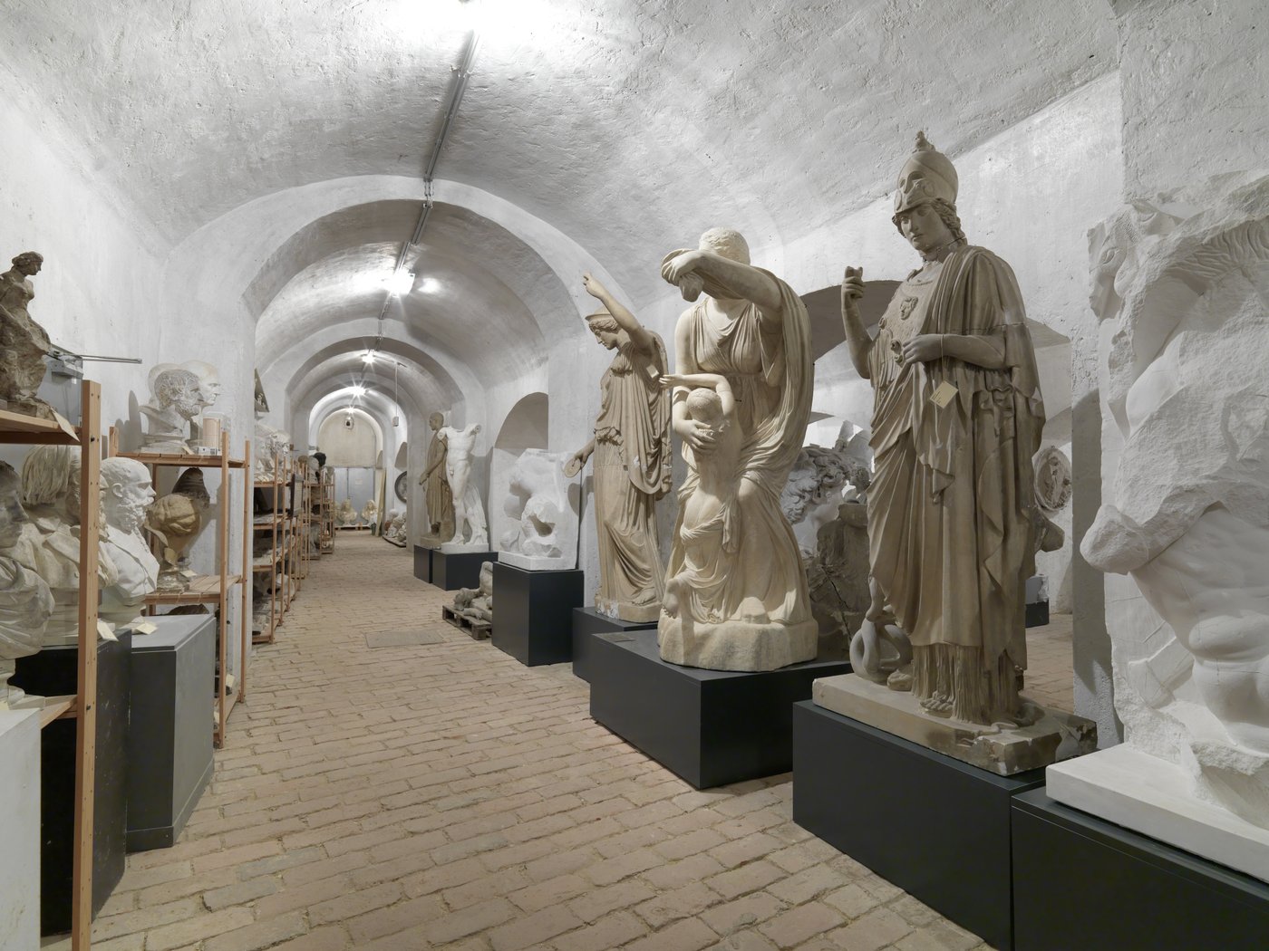 Foto von einem Raum mit Gewölbe in dem mehrere griechische Skulpturen in unterschiedlichen Posen eng aneinander gereiht stehen