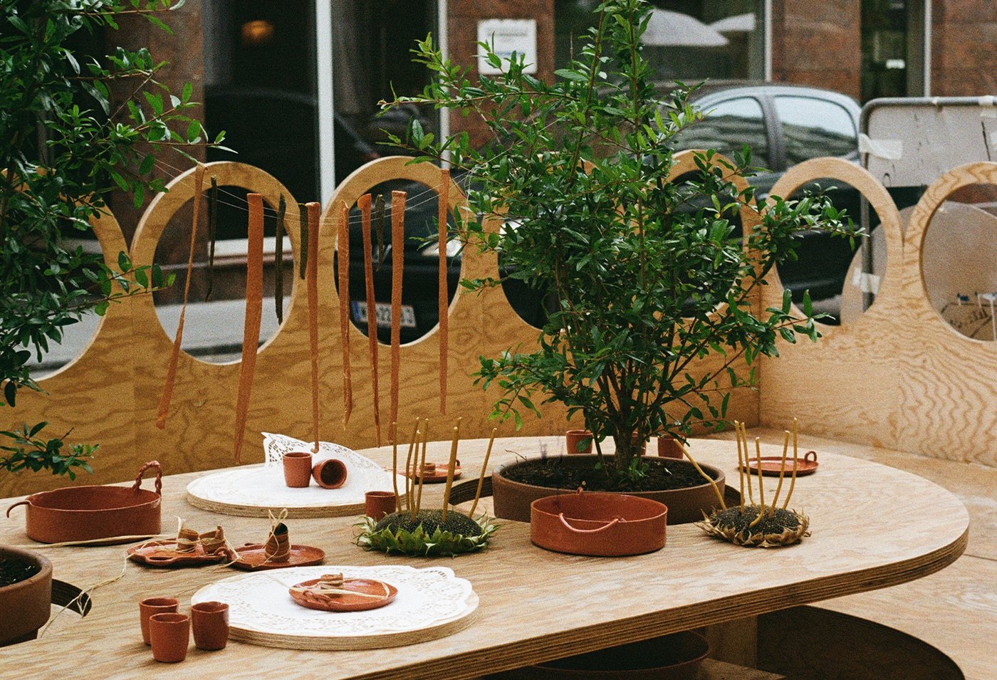 Holztisch und Bank mit keramik und ton gefäßen und pflanzen