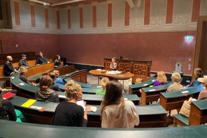 Studierende in einem Höhrsaal die zu der vortragenden Person blicken