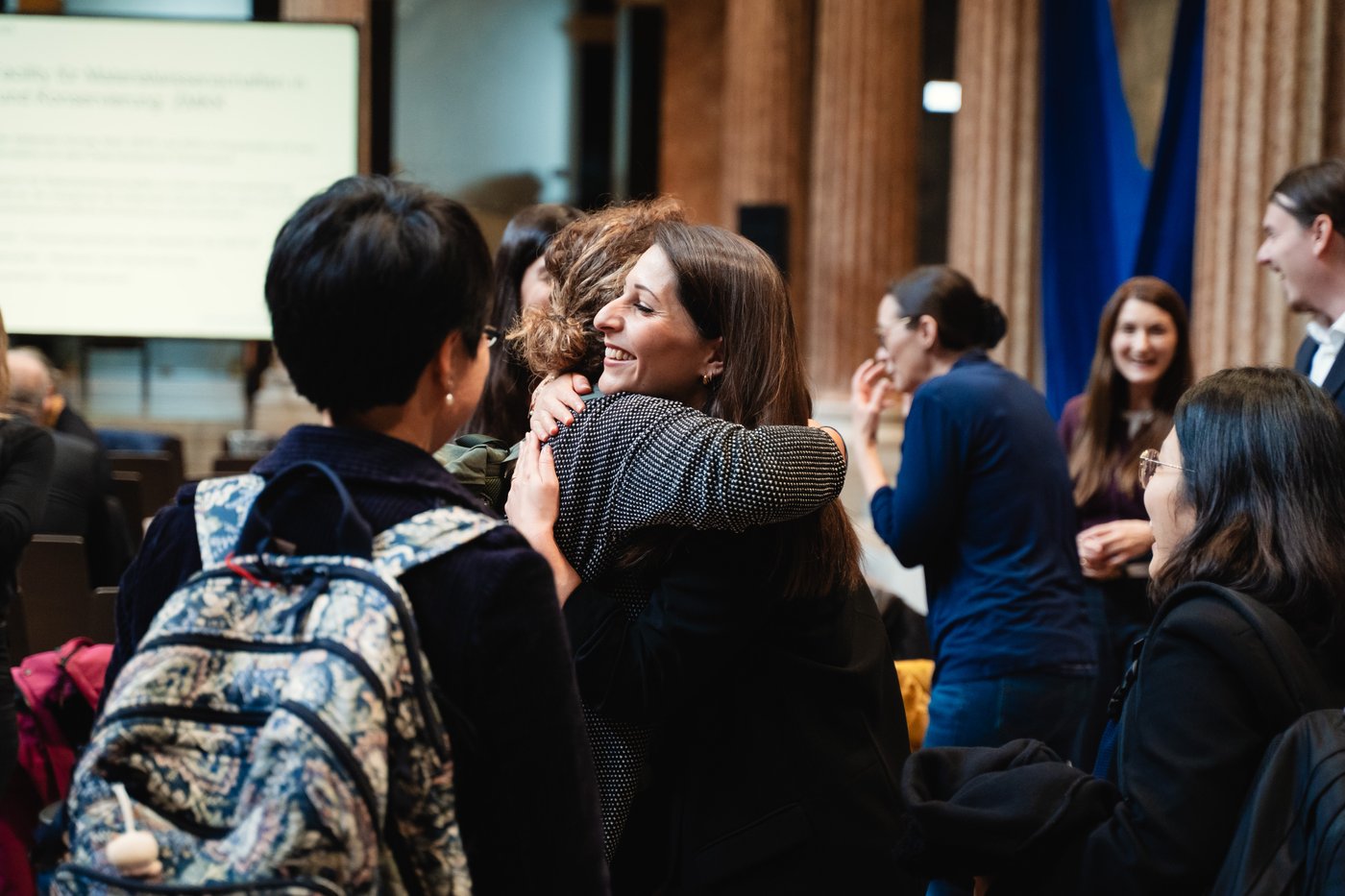 Zwei Personen im Publikum umarmen sich.