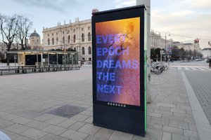 Werbegrafik auf einem Platz vor einem historistischen Gebäude