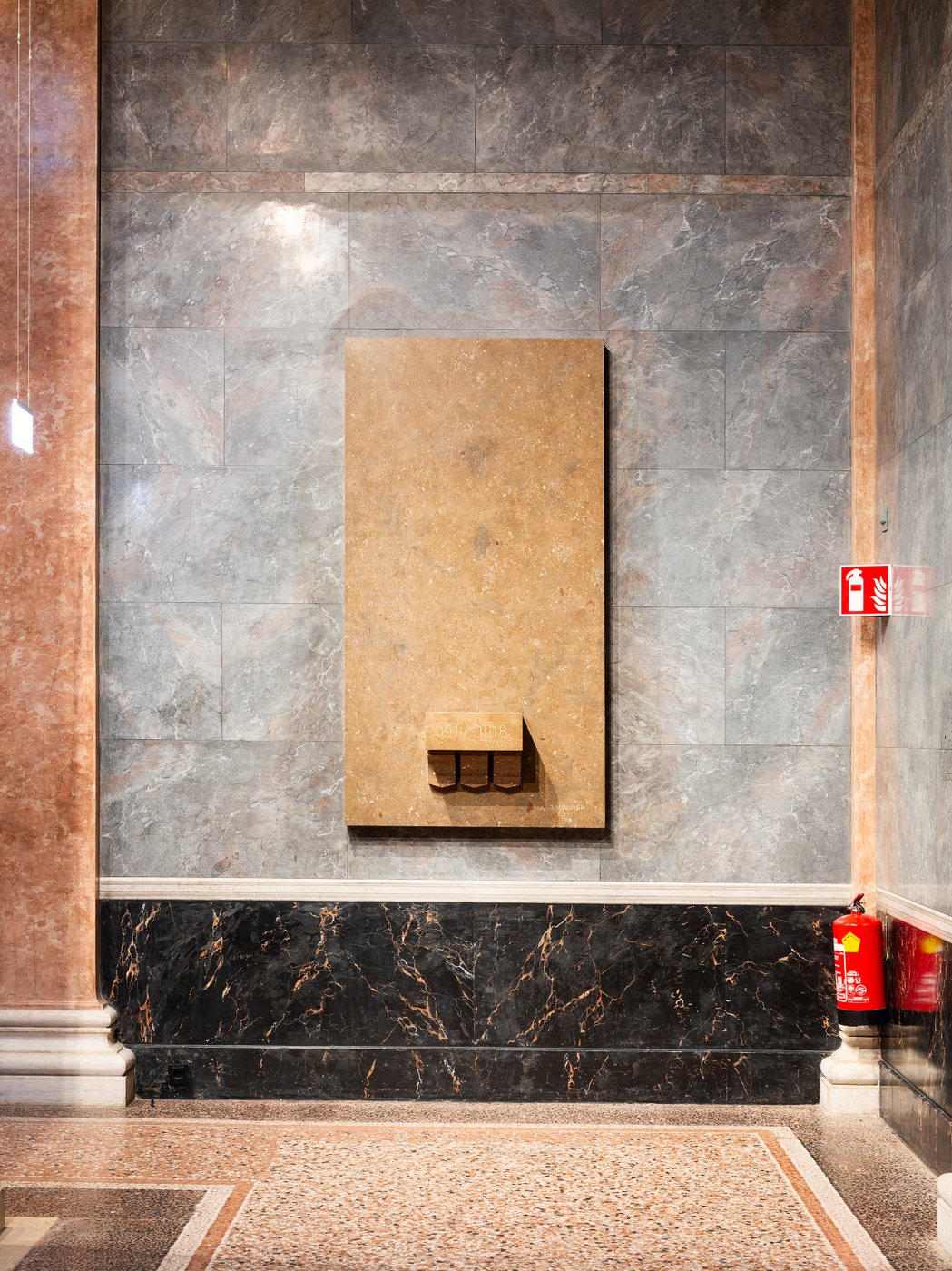 An einer Wand befindet sich ein leerer Sockel, wo einst eine Statue stand.