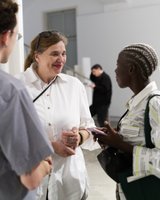 Elke Gaugele und Besucher:innen während der Ausstellung “Making, Memory and Resistance - Textile Healing and Social Justice through the Lens of Decolonial Fashion Research”in der Galerie Exhibit Eschenbachgasse, Foto: Sidonie Sagmeister/Anna Hambira