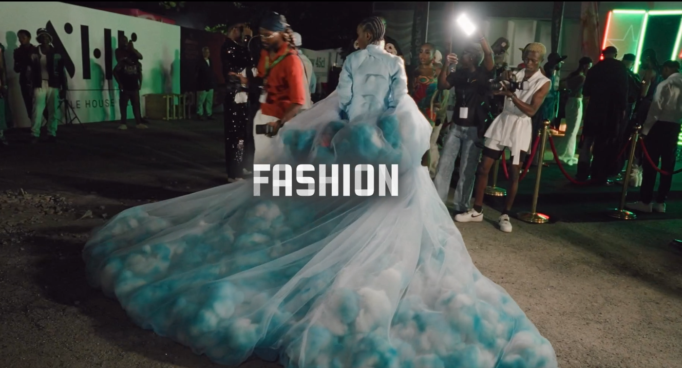 Rückenansicht einer Frau mit einem hellblauenabendkleid bei Nacht, in der Mitte in weißer Schrift das Wort "Fashion"