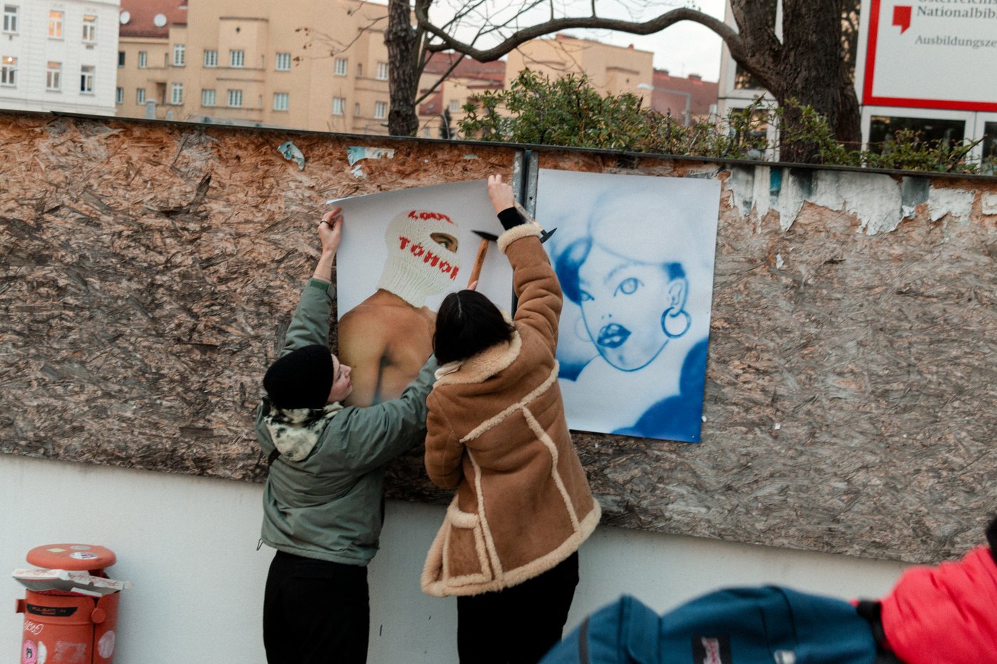 Studierende kleben Plakate an eine Wand
