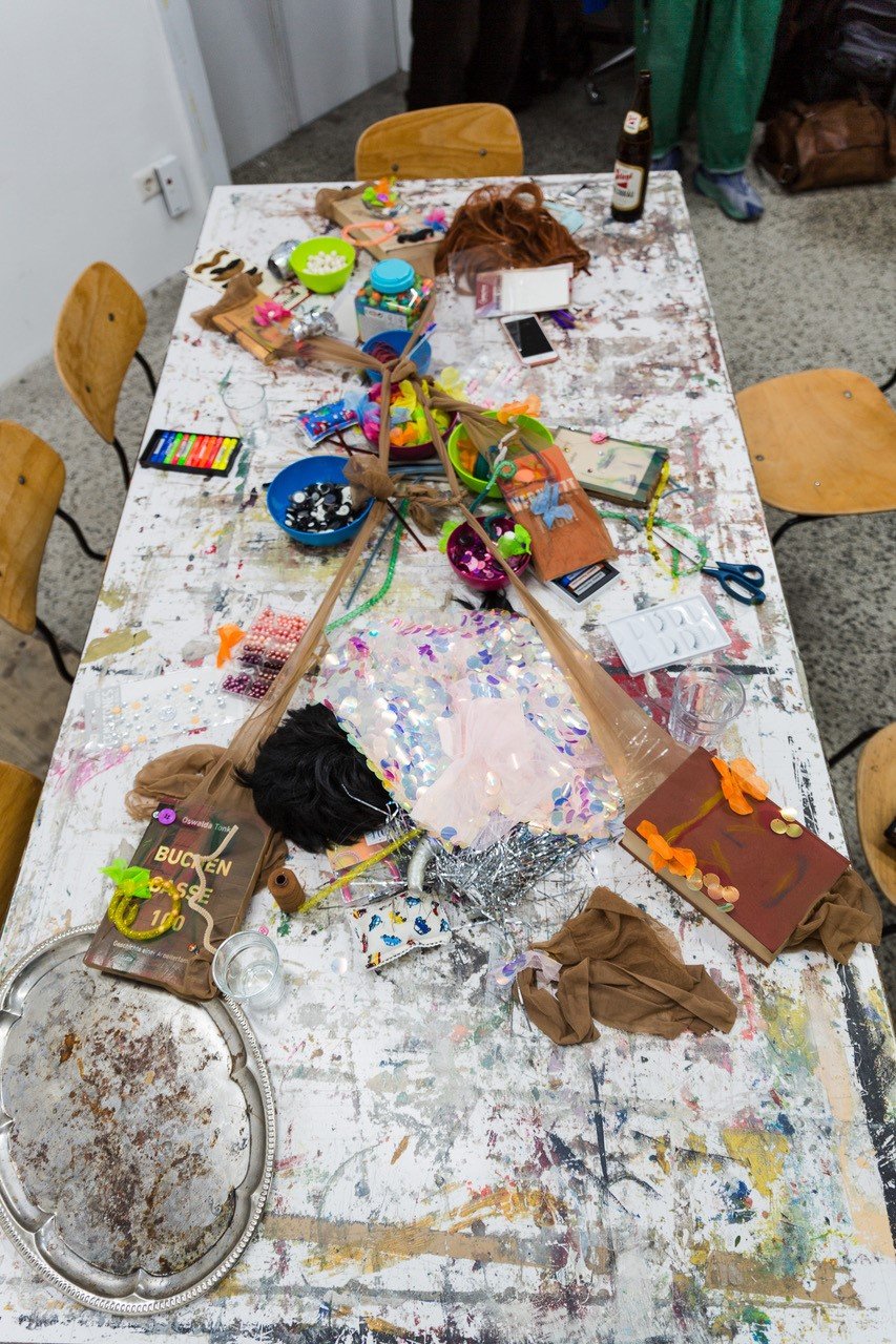 bunter Tisch voll mit künstlerischen Materialien, teilweise angemalt