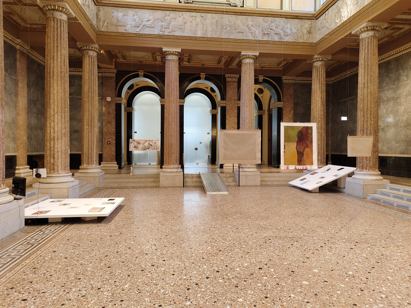 Kunstwerke hängen von der Decke einer großen Säulenhalle