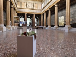 Ausstellungsraum mit Bildern die an Drähten hängen