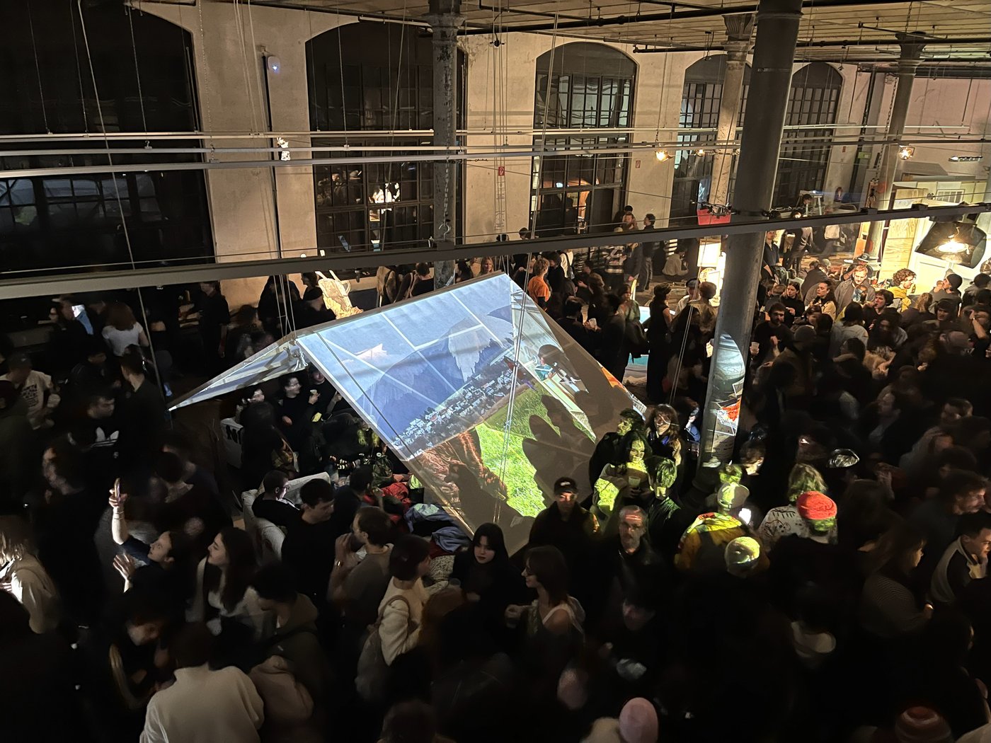 Das Bild zeigt Besucher in der Klasse für Bühnengestaltung während der Veranstaltung im Januar 2025. Auf ein Zelt wird eine Projektion einer Berglandschaft geworfen.