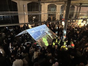 Das Bild zeigt Besucher in der Klasse für Bühnengestaltung während der Veranstaltung im Januar 2025. Auf ein Zelt wird eine Projektion einer Berglandschaft geworfen.