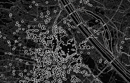 Dunkle abstrahierte Kartenansicht von Wien mit zahlreichen hellen kreisförmigen Markierungen und verdichteten Linienstrukturen, die digitale Erinnerungsorte und räumliche Vernetzungen visualisieren.