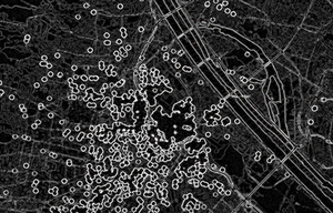 Dunkle abstrahierte Kartenansicht von Wien mit zahlreichen hellen kreisförmigen Markierungen und verdichteten Linienstrukturen, die digitale Erinnerungsorte und räumliche Vernetzungen visualisieren.