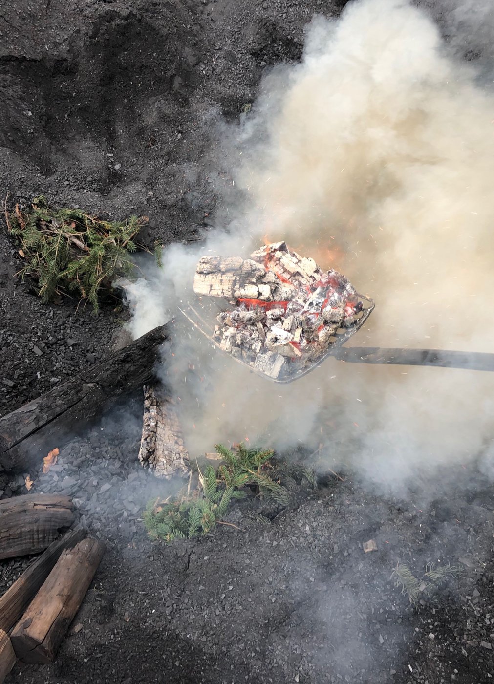 smoking coal and ashes with smoke and wood on the floor