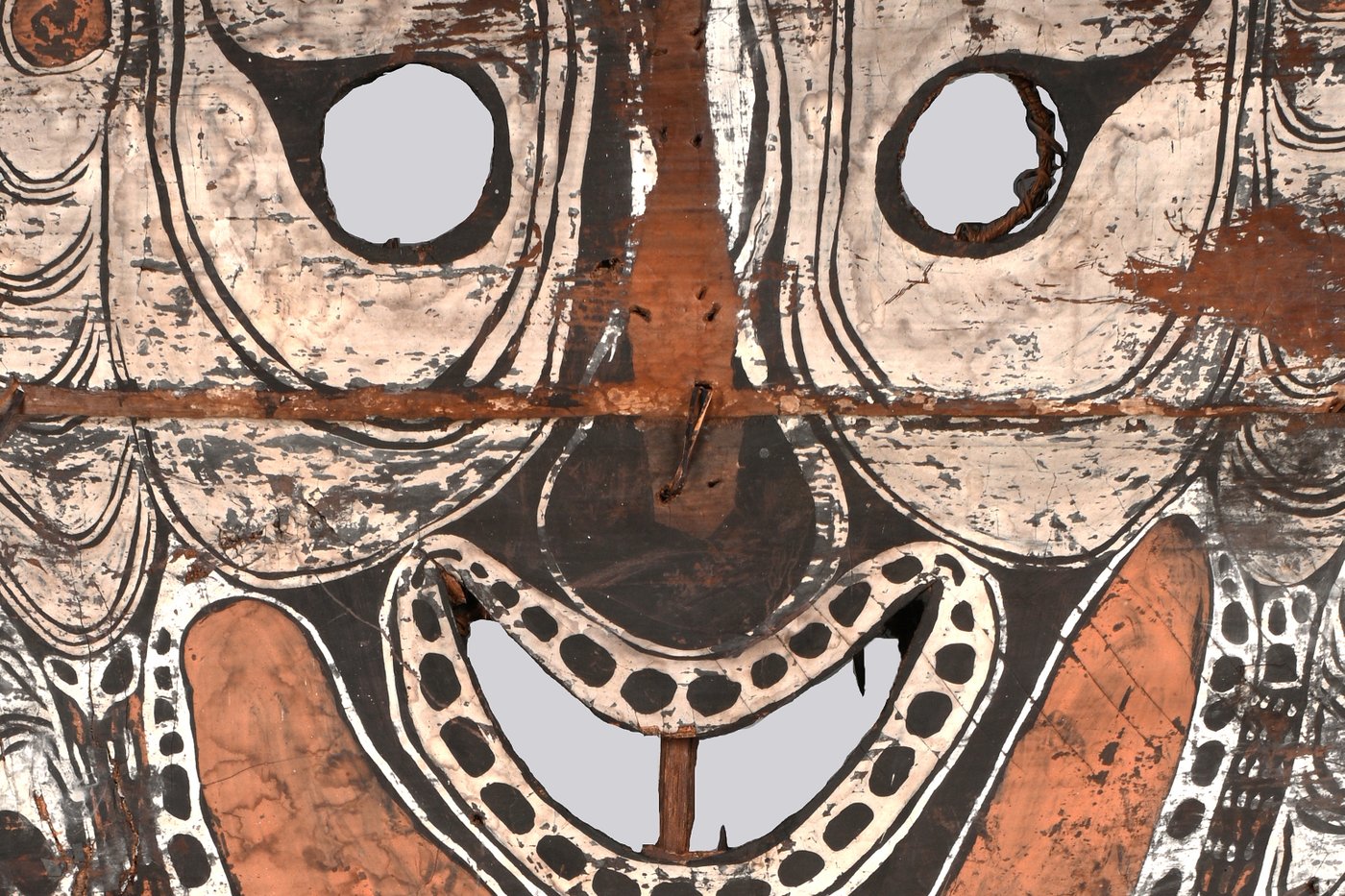 Photography, close up of African wooden mask with black and white patterns outlining facial features