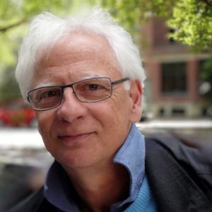 Portrait photo, about 60-year-old white man with short white hair and glasses