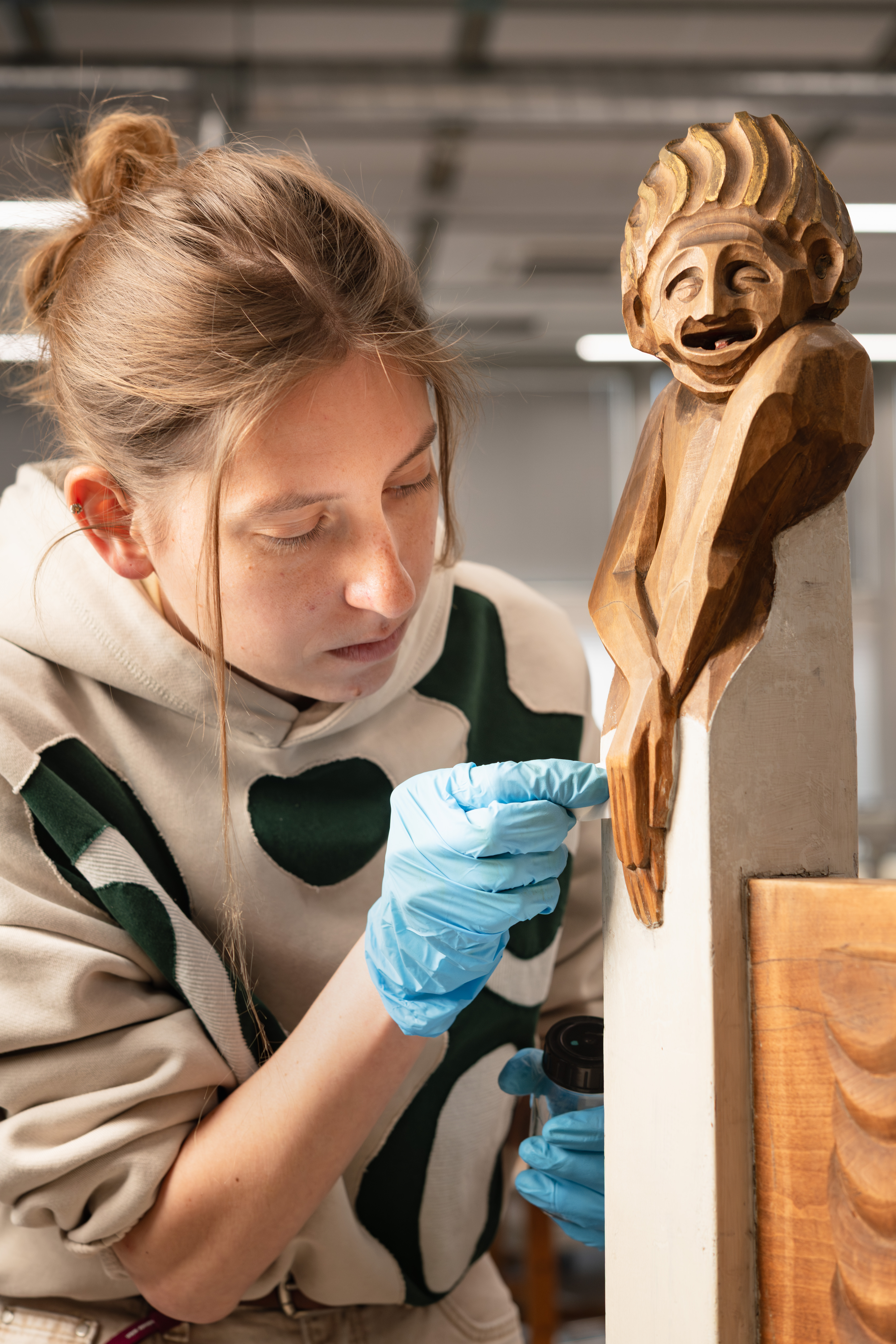 Close examination of a wooden sculpture in the Conservation and Restoration Studio specializing in Wood. Photo © Robert Vanis