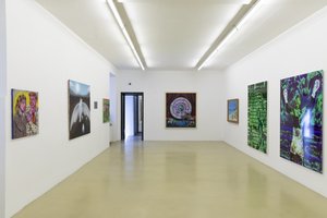 exhibition view with paintings on the wall