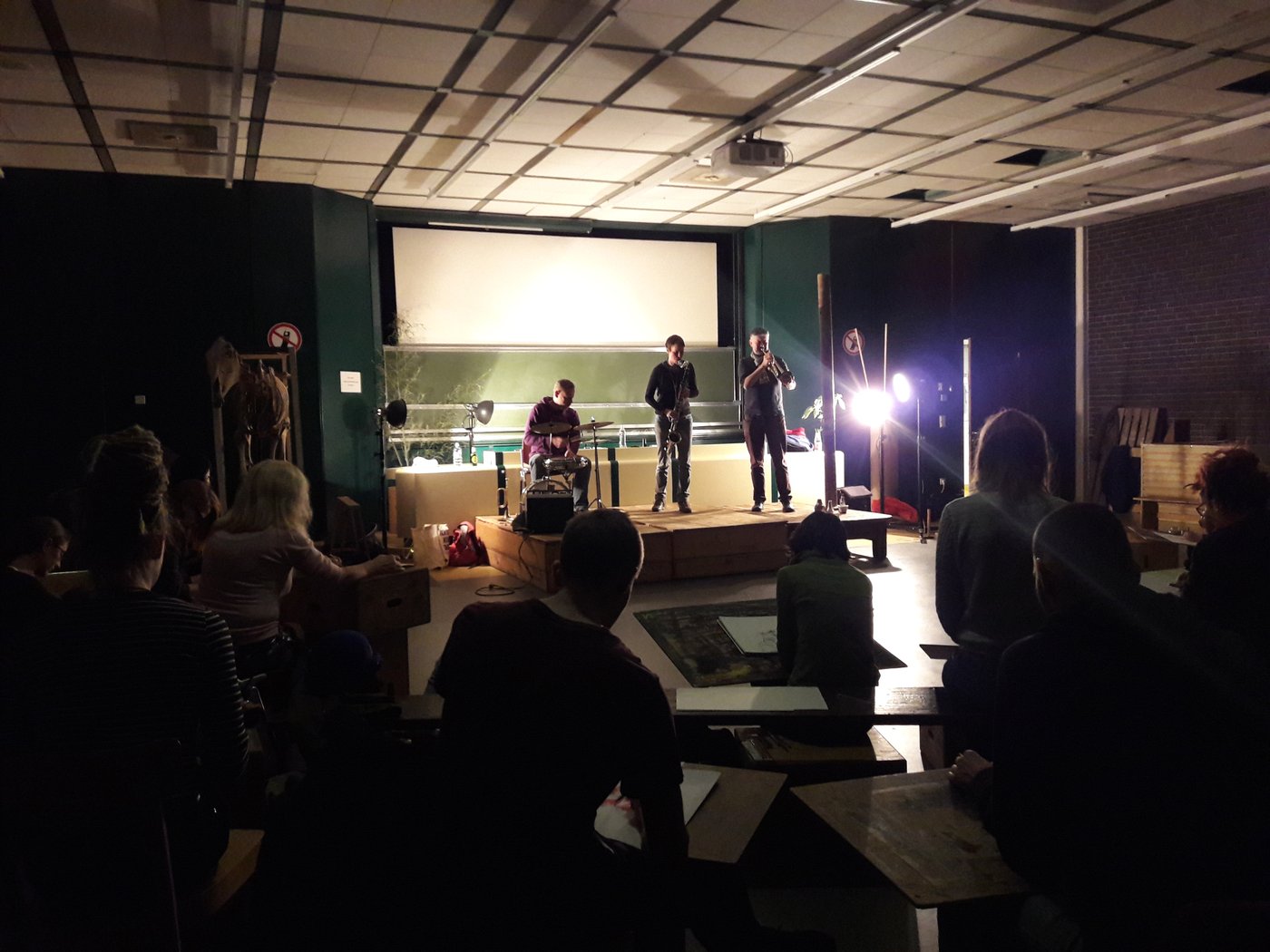 2 Three people on one stage and the audience in the nude hall