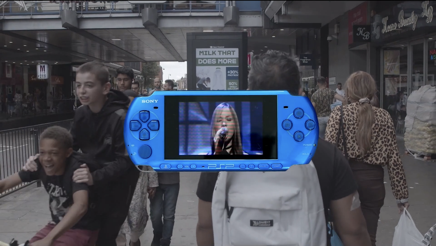 Play-Station with singer hovering in front of urban situation with passers-by