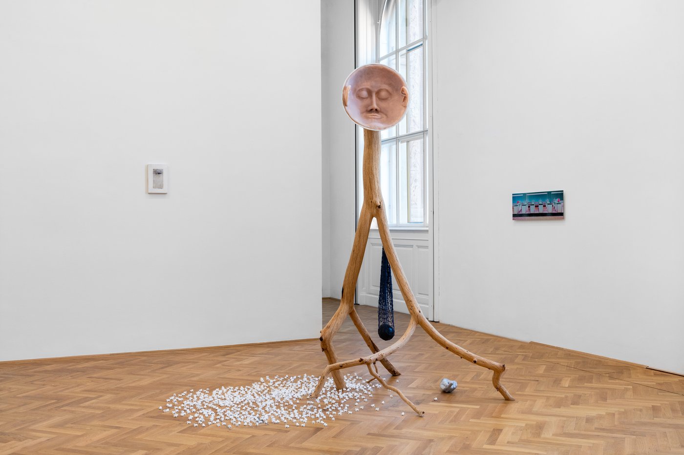 Art installation from wood with a face in a white room