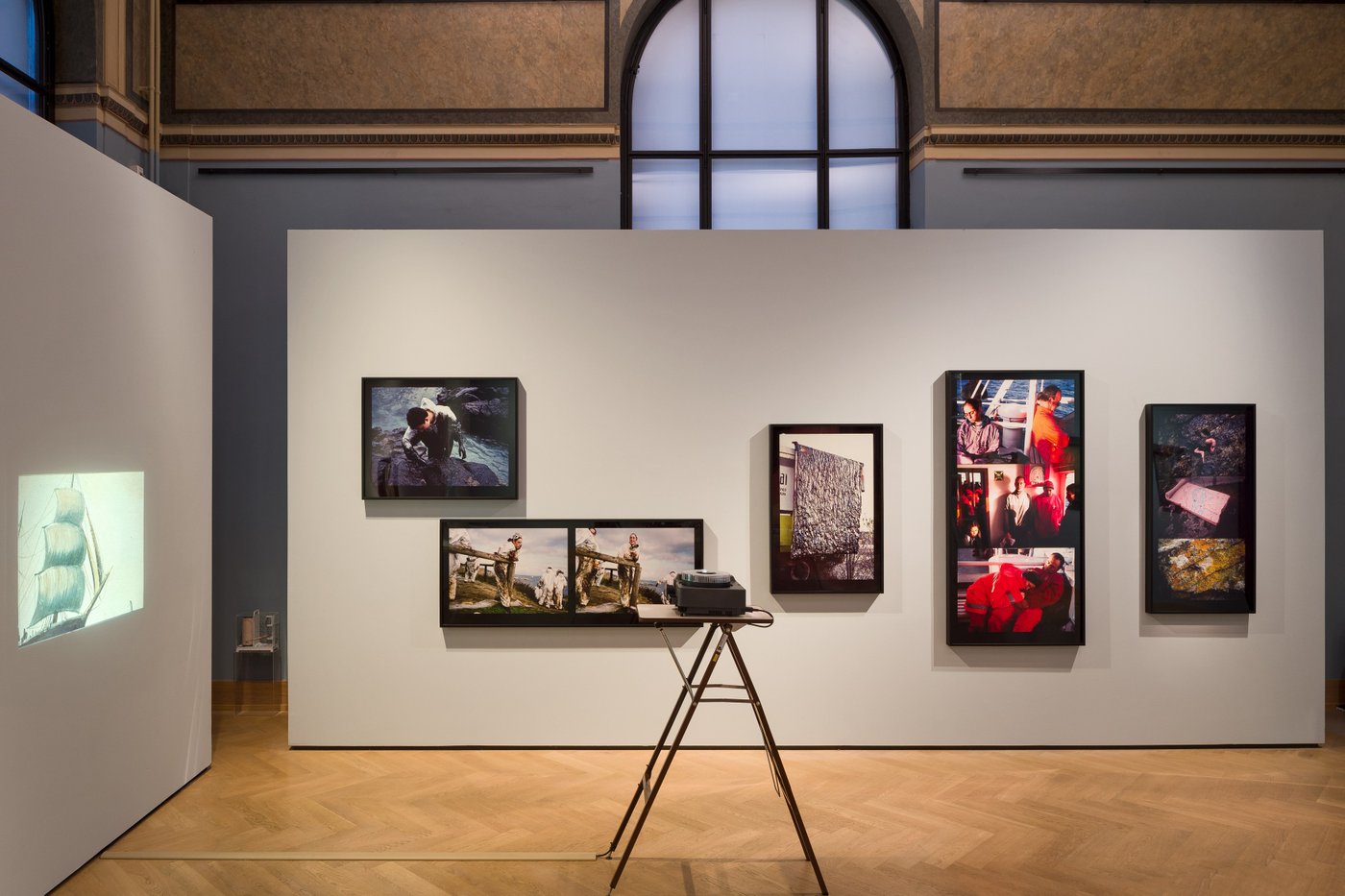 Picture of an exhibition view with different photos on a wall