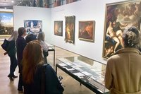 a group of people in an exhibition tour in a room full of oil paintings