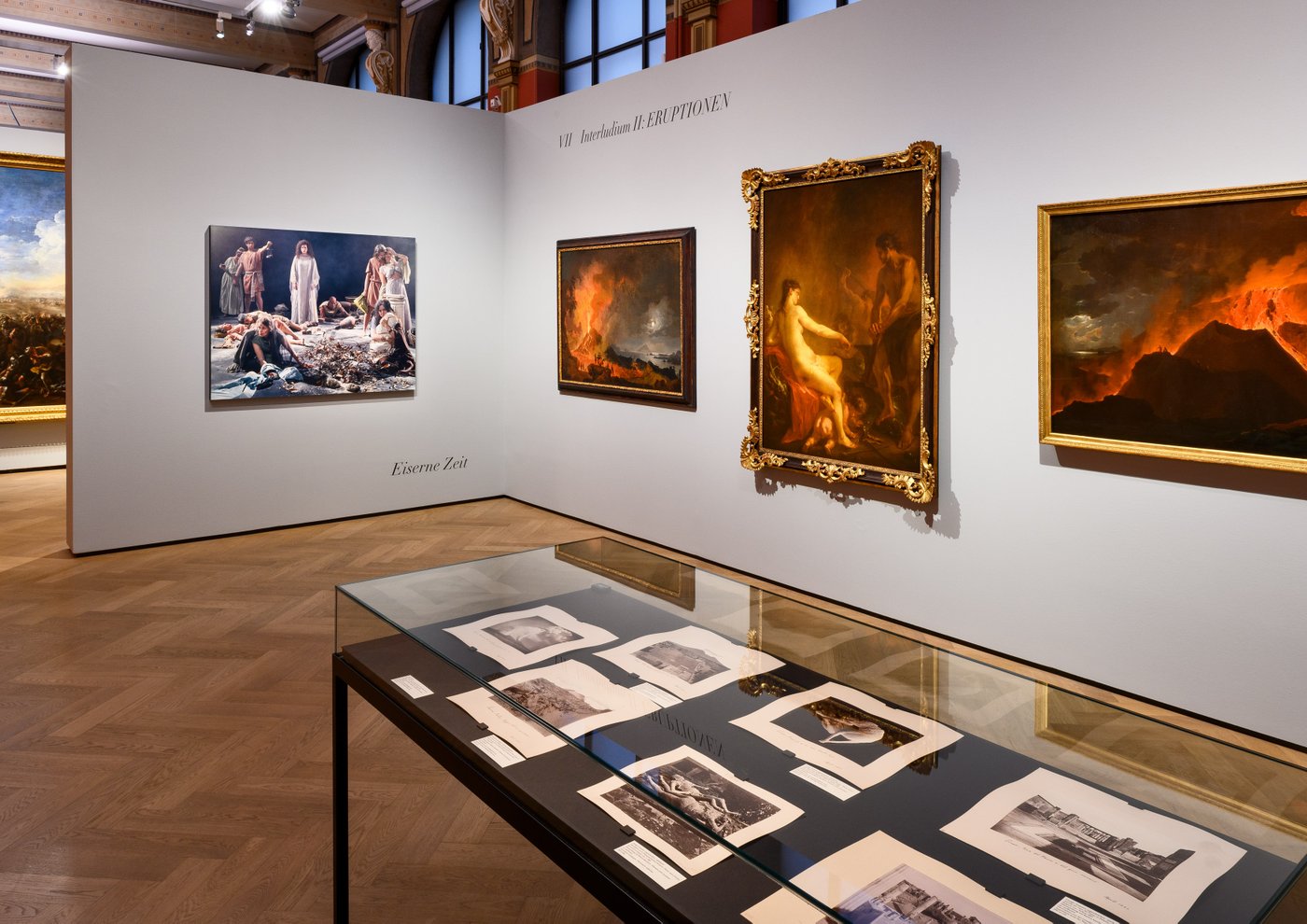 a room that exhibits art on the wall with many old colorful oil paintings