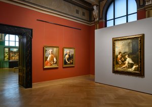 a few paintings on red and grey walls in an exhibition room