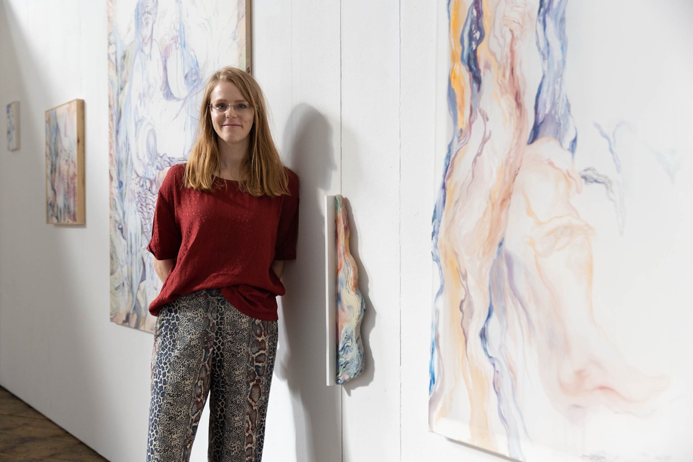 A woman standing in front of her Paintings
