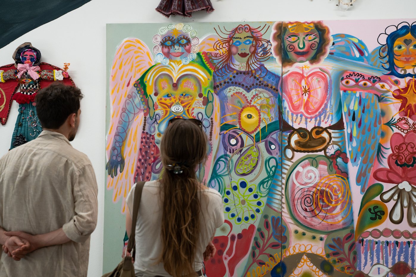 two people in front of a colorful artwork