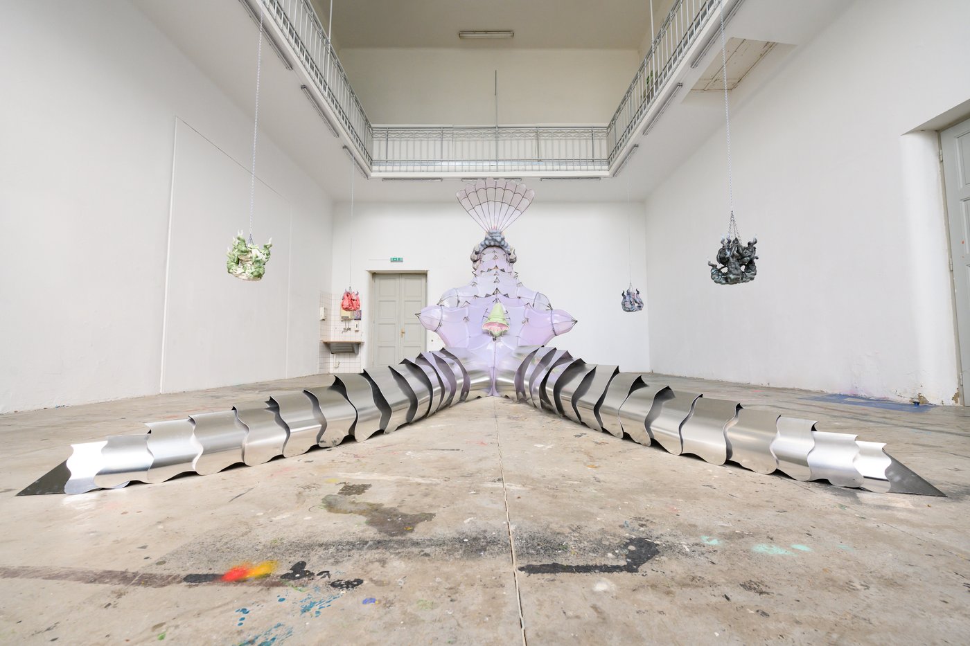 Diploma work with a huge piece in the middle of the room looking like a monster with tentacles and pieces hanging around it