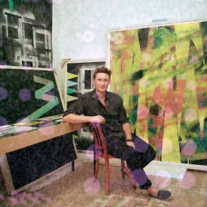 Picture of a man dressed in black who is sitting on a chair in the middle of live sized drawings