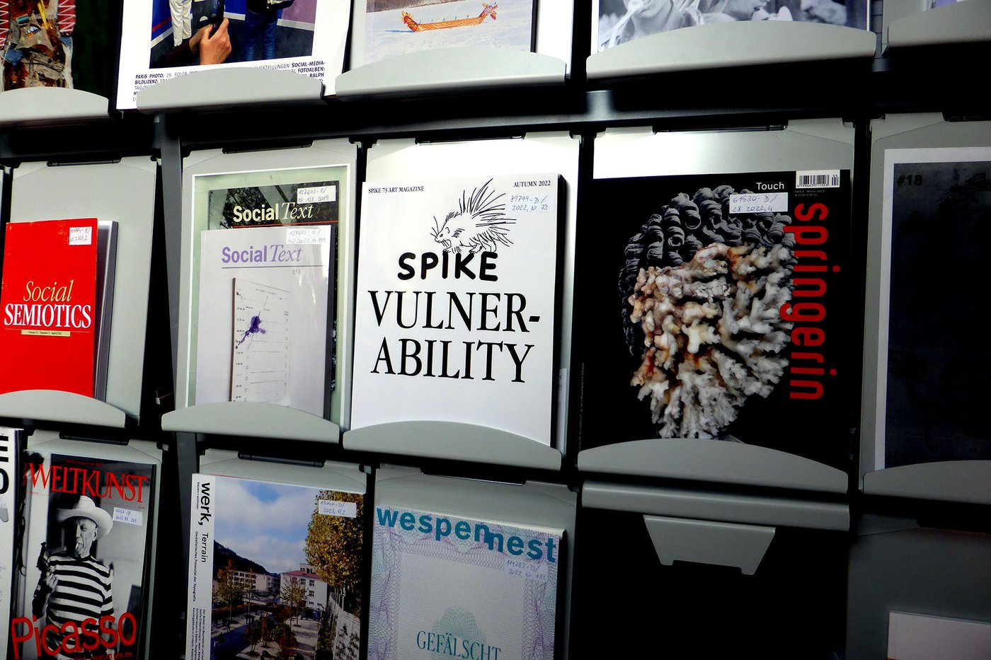 Magazine shelf in the Academy Library with hot off the press titles from the arts and sciences. Among others, the following magazines can be recognized: "Social Semiotics", "Social Text", "Spike", "Weltkunst", "werk, bauen+wohnen", and "wespennest".