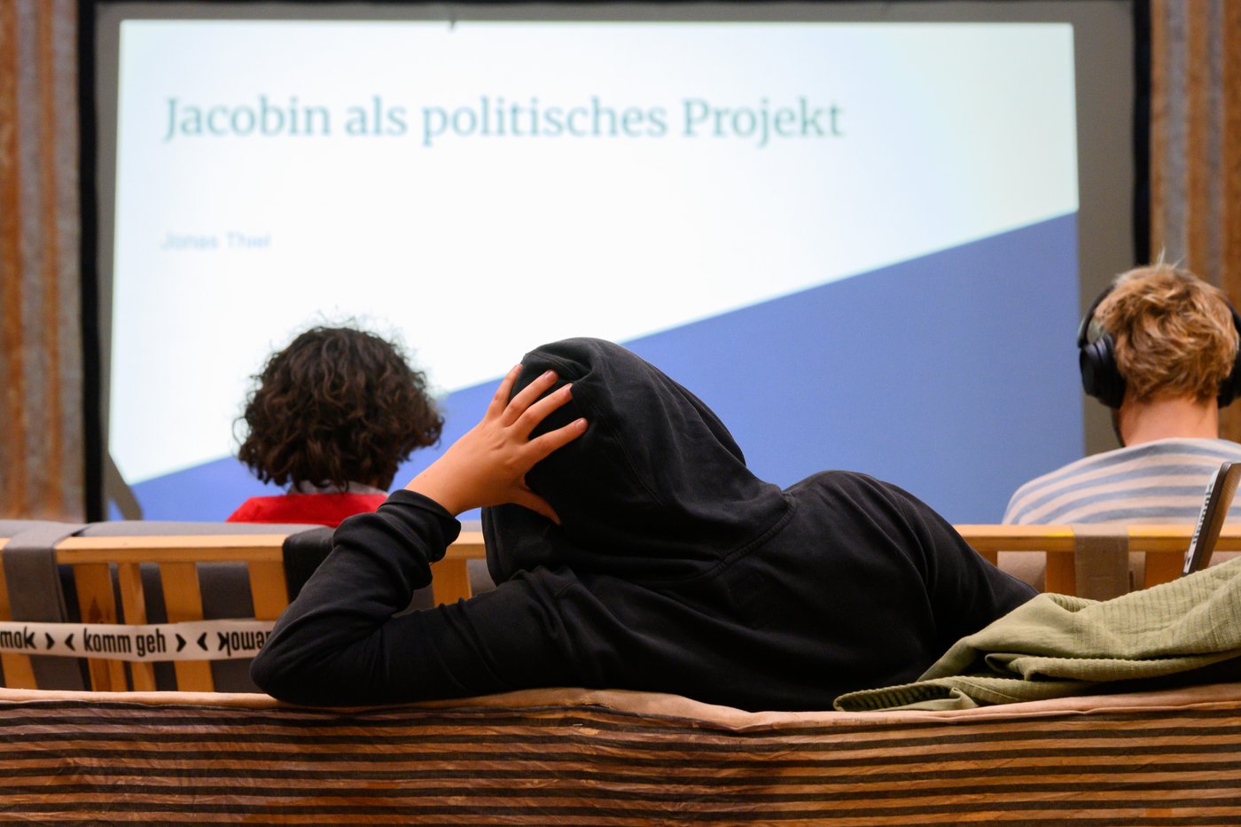a man in a hoodie looking at the screen