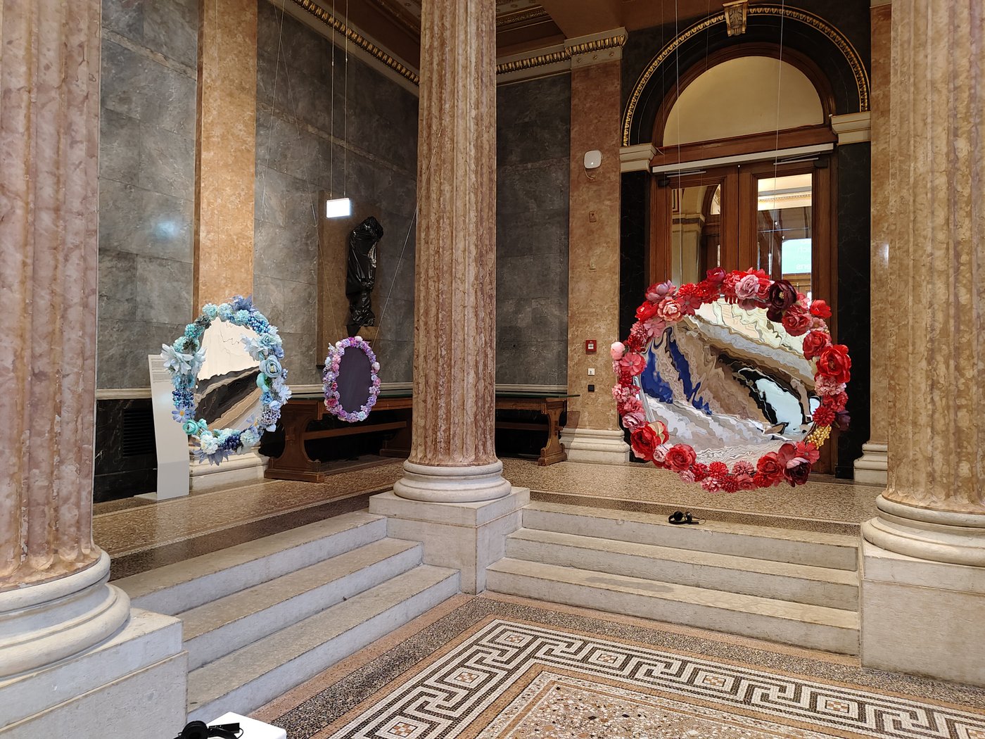 Flower mirrors hanging from the ceiling in a hall